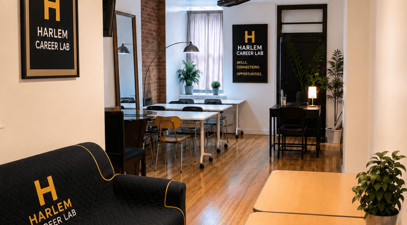 Modern Harlem Career Lab interior featuring white tables, wooden floors, and branded black furniture.