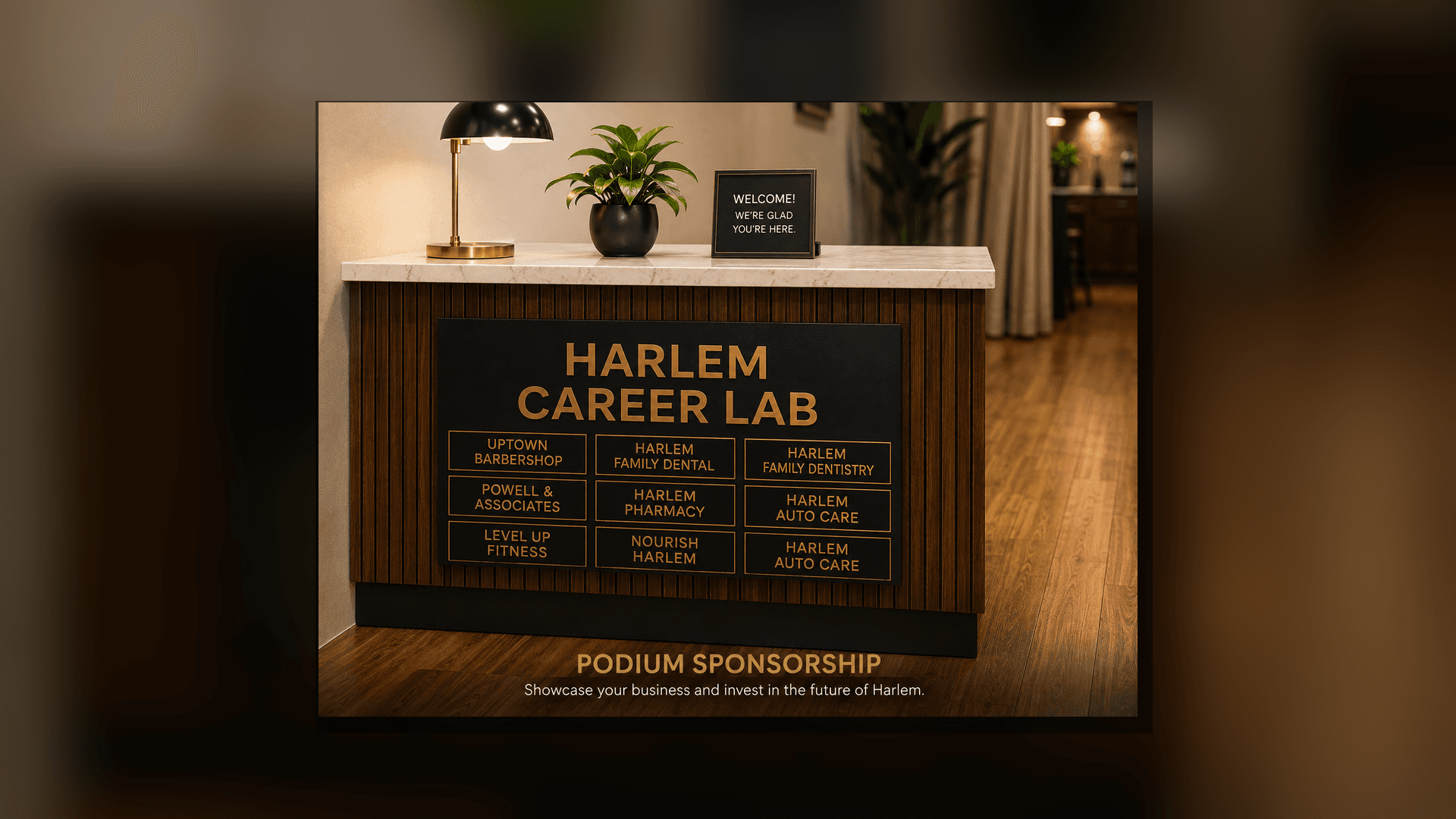 Harlem Career Lab podium featuring gold-lettered local business sponsors, a desk lamp, and a plant.